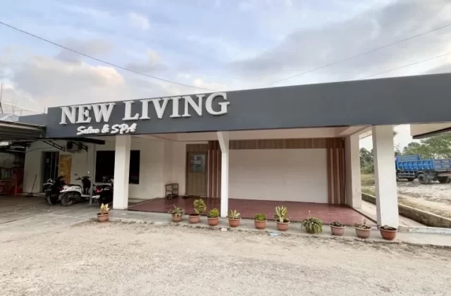 The exterior of New Living Salon & Spa in Waikabubak features a grey facade with white lettering, potted plants, and parked motorbikes under a cloudy sky.