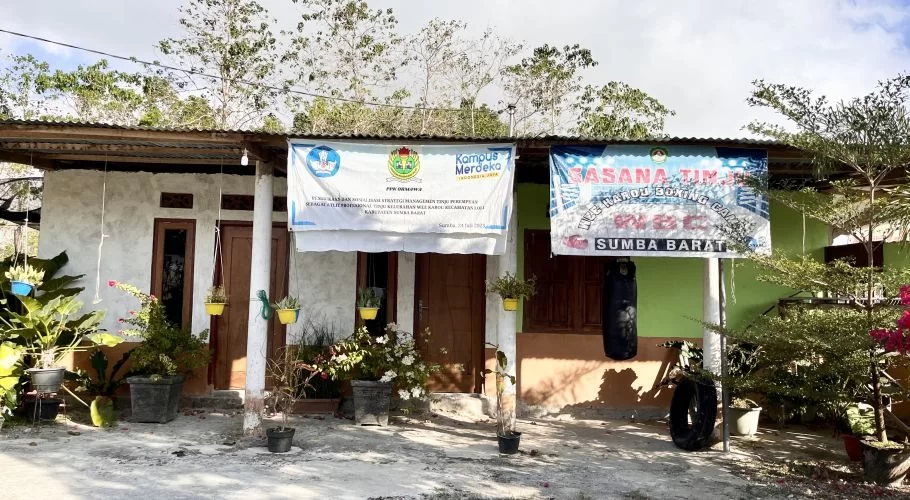 A modest, light-colored building with a corrugated roof displays two banners, one for Wee Karou Boxing Club, and a black punching bag hangs outside.