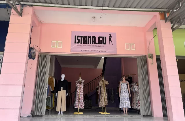 The pink storefront of Istana.Gu fashion store features three mannequins displaying dresses and a black top with beige pants, with more clothes visible inside.